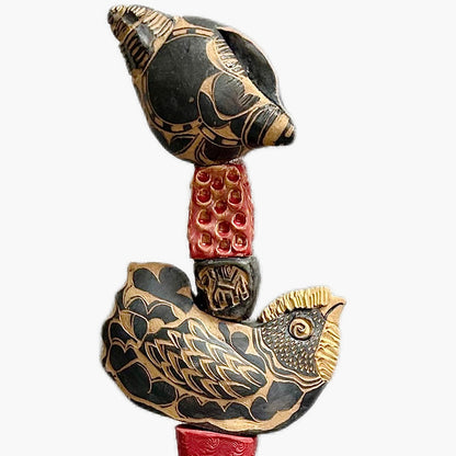 The Black Shell by Zimmerman – full view of nocturnal totem with face from deep black cylinder with gold accents and red collar warmth