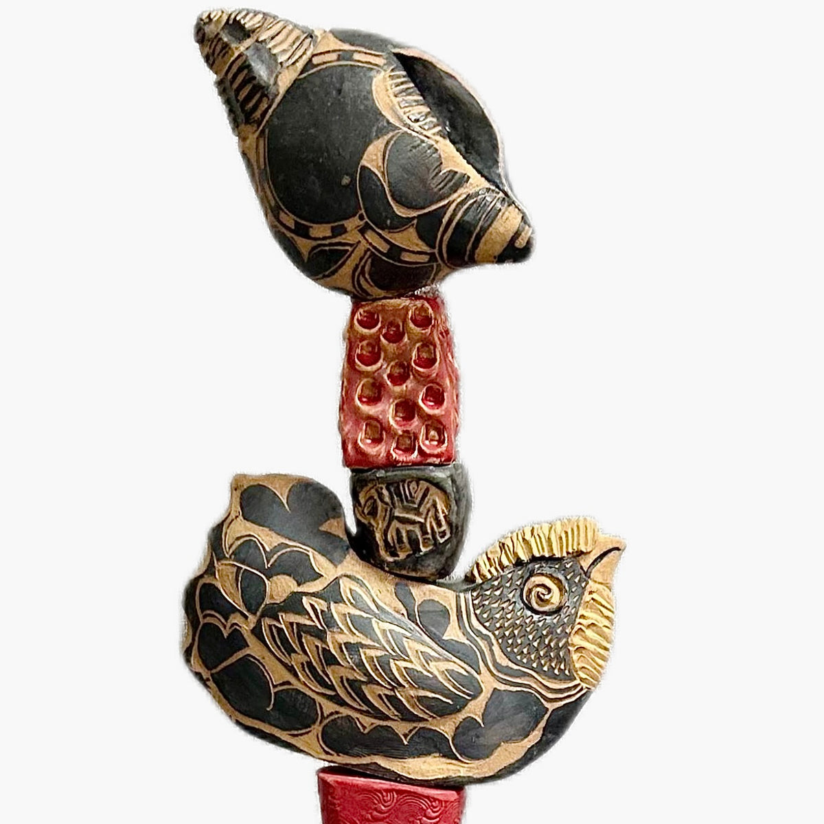 The Black Shell by Zimmerman – full view of nocturnal totem with face from deep black cylinder with gold accents and red collar warmth