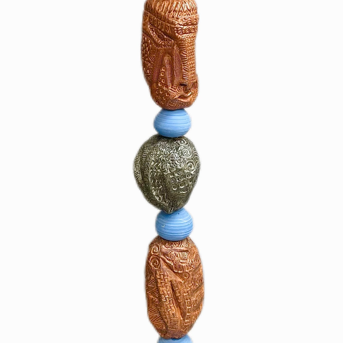 Stone Perch 4 by Zimmerman – full view of copper-bronze and slate totem with warm face near middle in easy downward rhythm