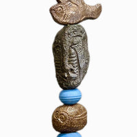 Stone Perch 5 by Zimmerman – detail of smooth periwinkle blue form beside richly textured bronze sphere with incised lines in Stone Perch series
