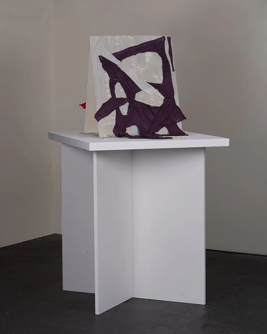 With-Without – sculptural object by Terese Garcia on white plinth with white and deep purple fabric or paper torn and folded into open vessel-like form, raw purple cutting through white with force